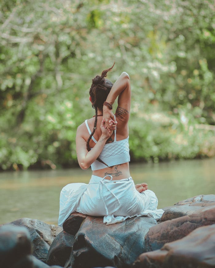 services-img A woman in a yoga pose by a calm river, surrounded by nature, embodying peace and tranquility.
