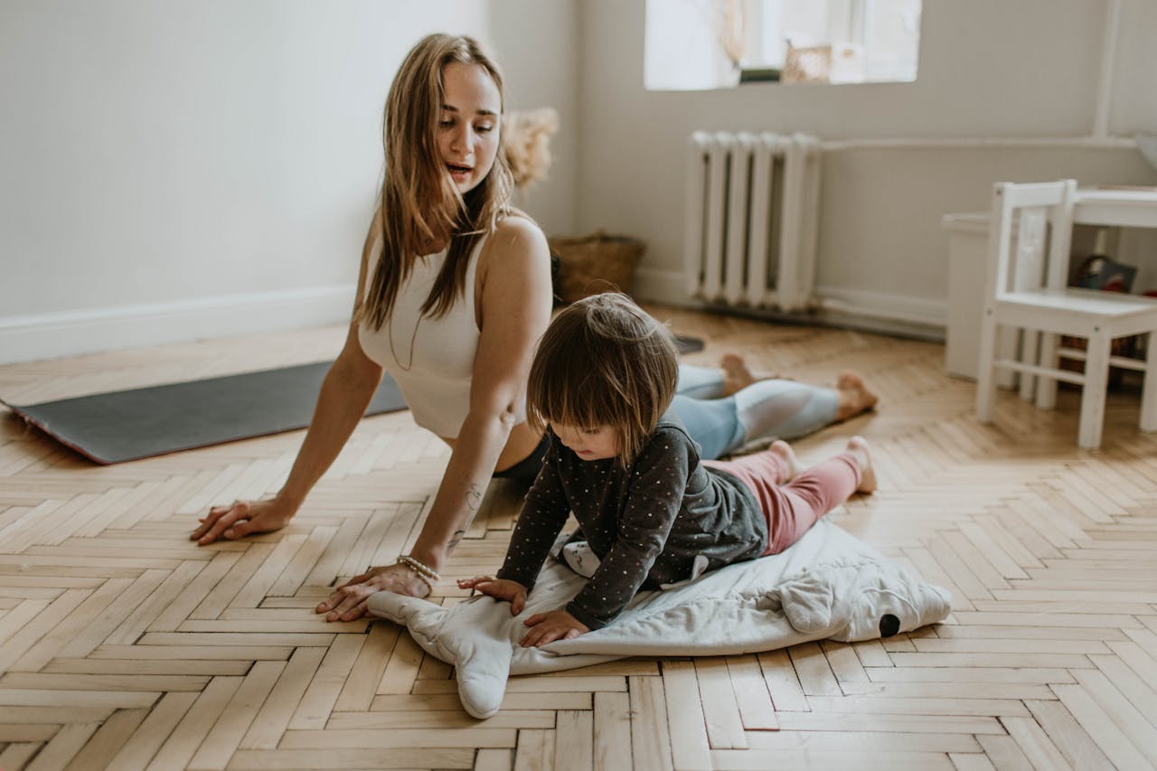 services-03 A mother and child practicing yoga together at home on a sunny day, fostering wellness and connection.